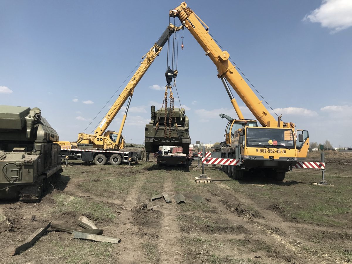 Два автокрана поднимают тяжёлую технику в тандеме